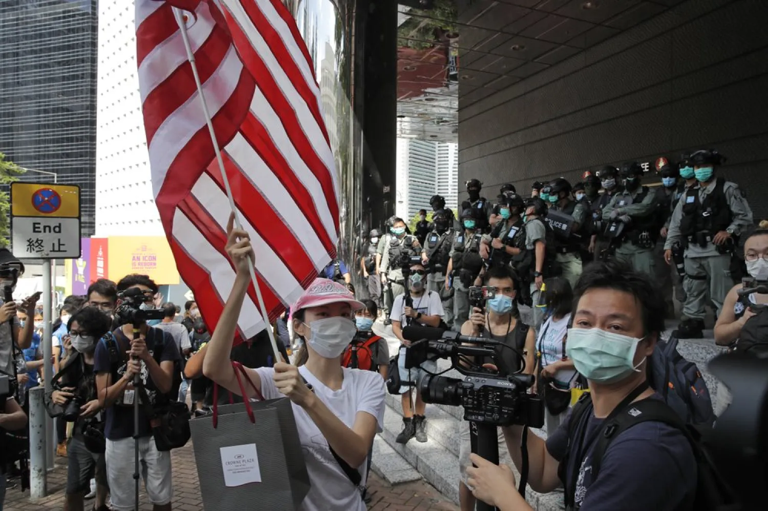 FILE - In this July 4, 2020, file photo, a woman carries an American flag during a protest outside the US Consulate in Hong Kong. AP
