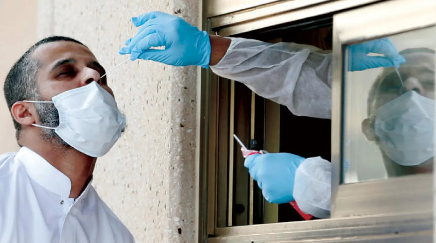 فحص «كورونا» في جسر الملك فهد (رويترز)