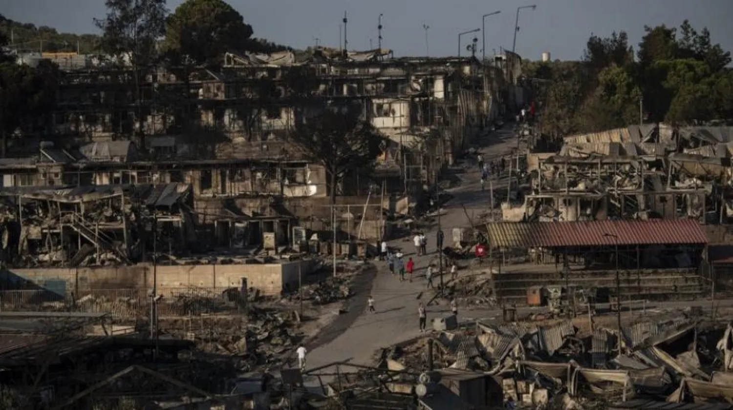 Migrants walk at the burned Moria refugee after a fire, on the northeastern Aegean island of Lesbos, Greece, on Wednesday, Sept. 9, 2020 (AP Photo/Petros Giannakouris)
