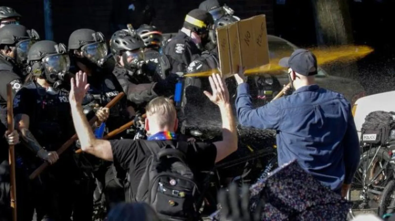 ضباط شرطة يستخدمون رذاذ الفلفل خلال اشتباكهم مع المتظاهرين في سياتل (أ.ف.ب)