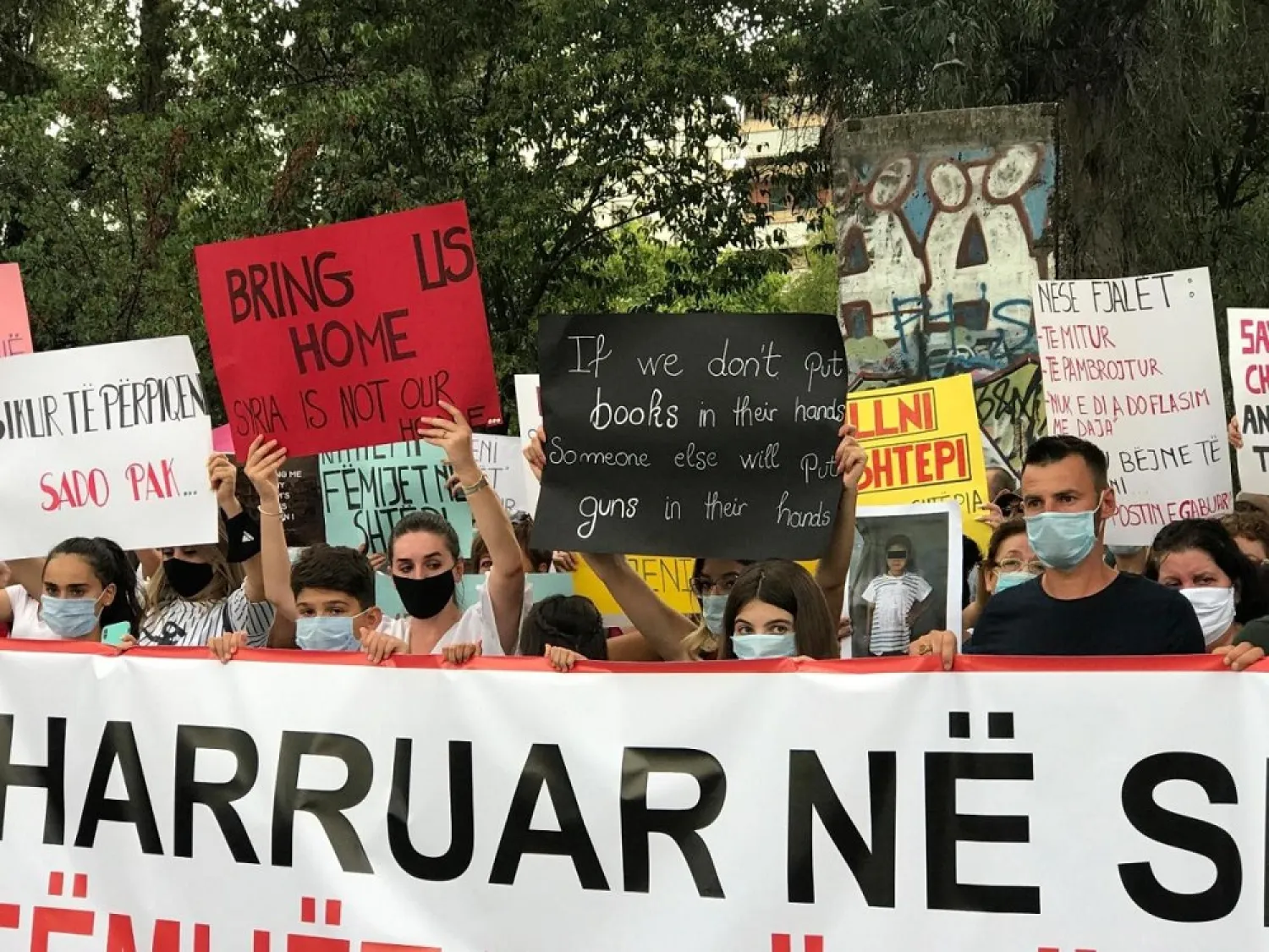 Protesters hold up placards during a rally in front of the government building in Tirana, Albania, Monday, Sept. 14, 2020. (AP)