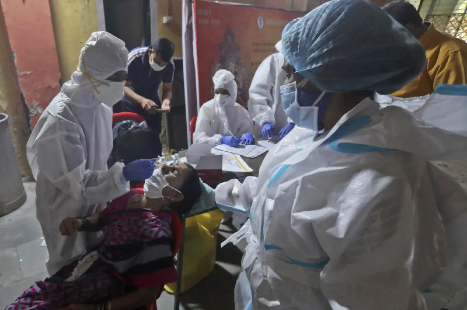 عاملون صحيون يأخذون عينة مسحة لاختبار «كورونا» في مومباي (أ.ب)