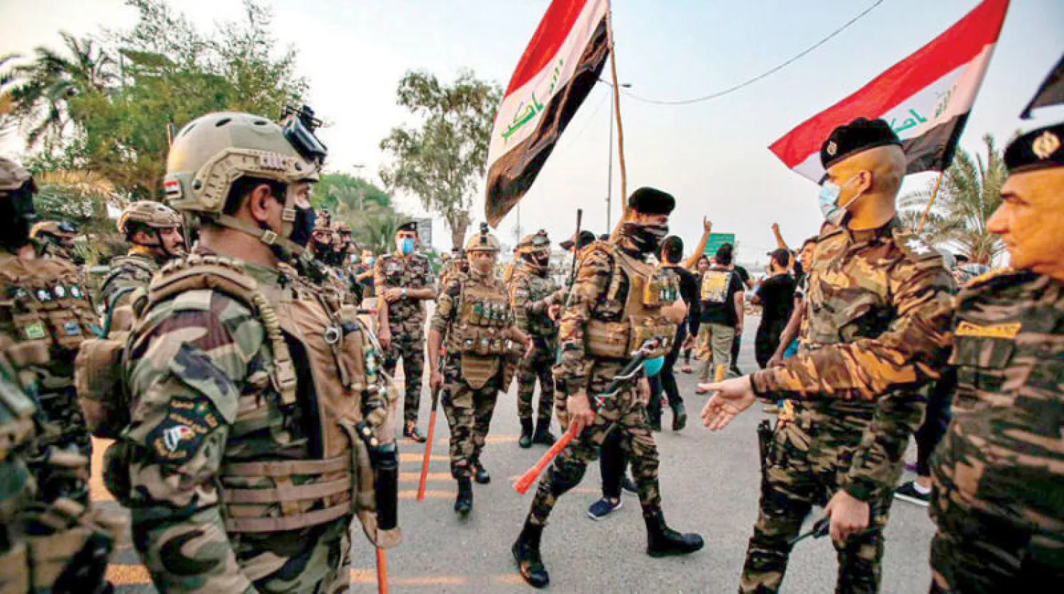 قوات عراقية تمنع متظاهرين من اقتحام مبنى المحافظة خلال احتجاجات في البصرة (أ.ب)