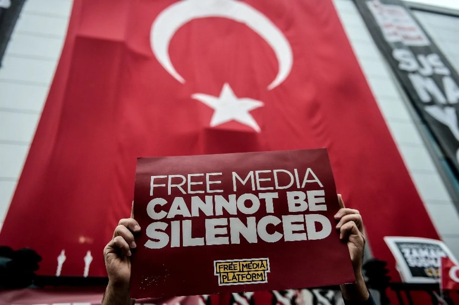 A protester holds a sign during a rally in Istanbul against the Turkish government's crackdown on media outlets on October 27, 2015. (AFP)