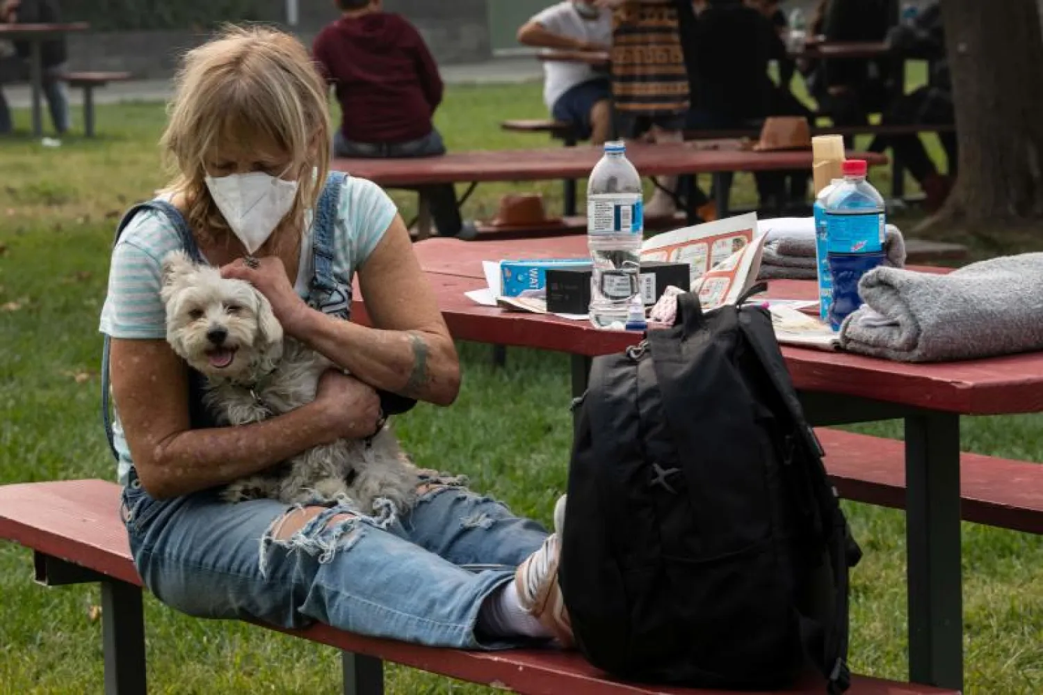 سيدة أميركية تحمل كلبها في ولاية أوريغون (أ.ف.ب)