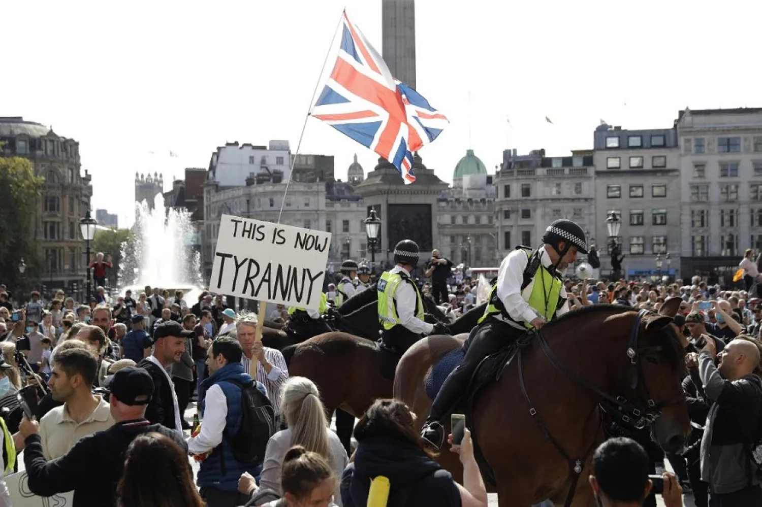Police officers on horse-back stand next to protesters during a ‘Resist and Act for Freedom’ protest in Trafalgar Square, London, Saturday, Sept. 19, 2020. (AP)