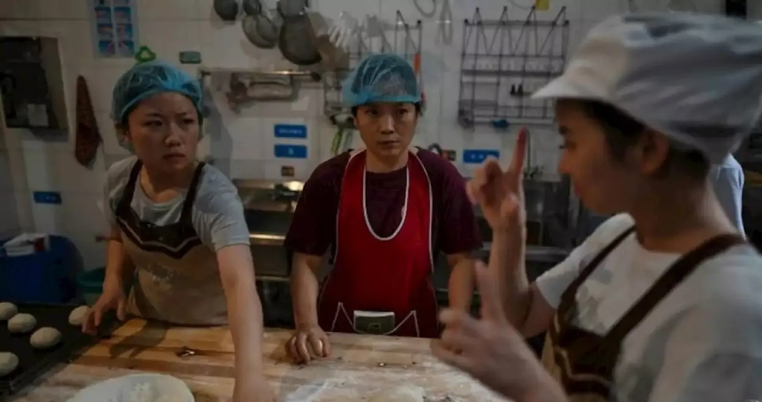 Hearing-impaired employees use sign language while working at the bakery run by Uwe Brutzer in Changsha in central China. (AFP)