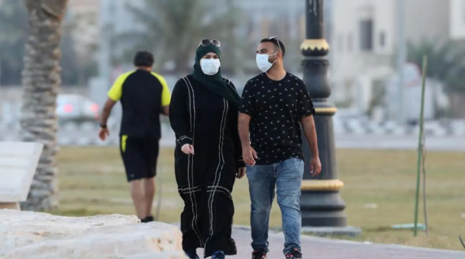 File photo: A couple wear a protective face mask, as they walk, in Saudi Arabia. REUTERS/Stringer