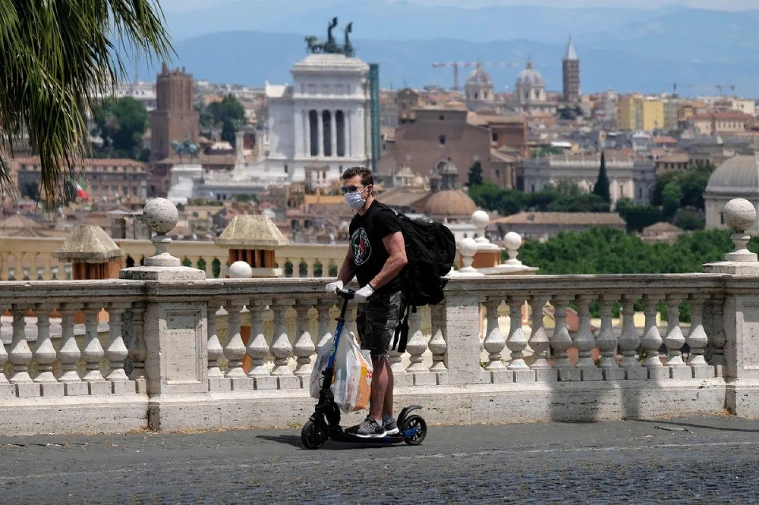 A man rides an electric scooter from the E-TWOW sharing service on Piazza del Gianicolo overloooking Rome on May 28, 2020. (Getty Images)