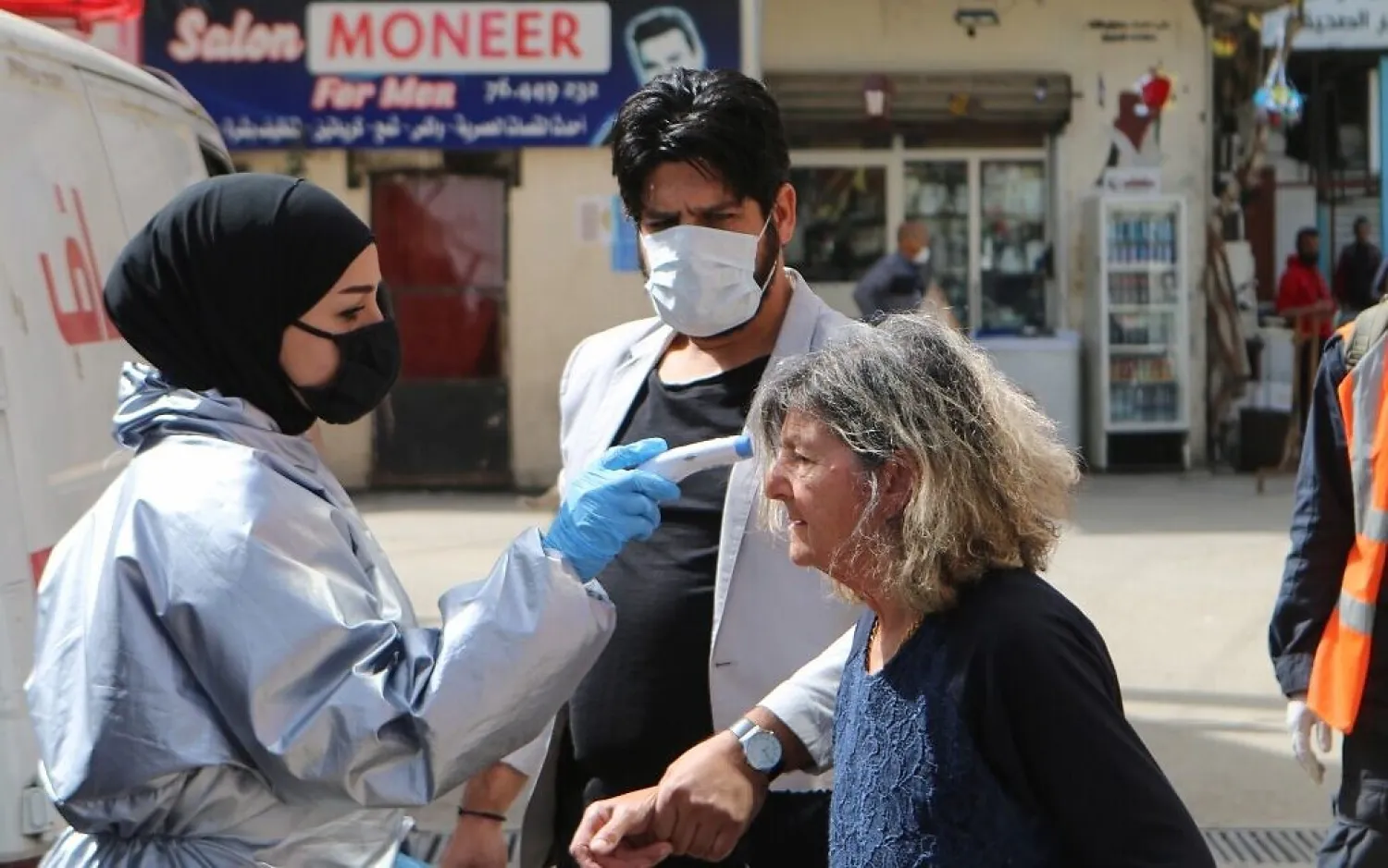A medic checks the temperature of a woman at the Wavel camp for Palestinian refugees in Lebanon's eastern Bekaa Valley, on April 22, 2020, after the UN announced the first confirmed case of coronavirus there. AFP