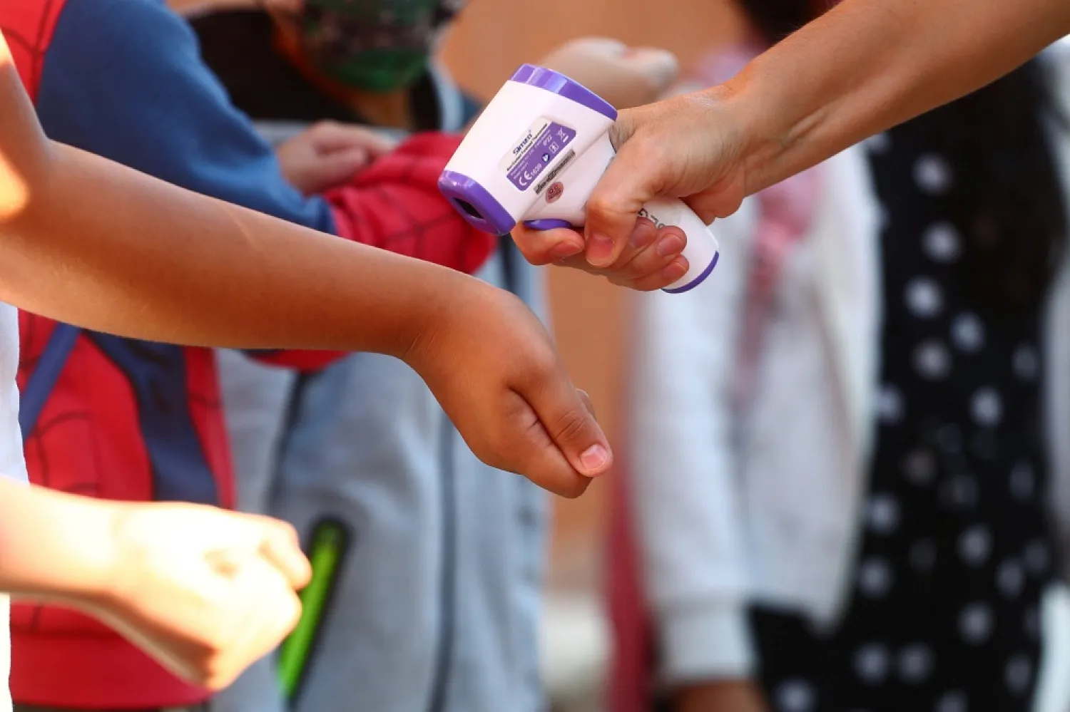 Pupils have their temperature checked before entering on the first day of school amid the coronavirus outbreak in Madrid. (Reuters)