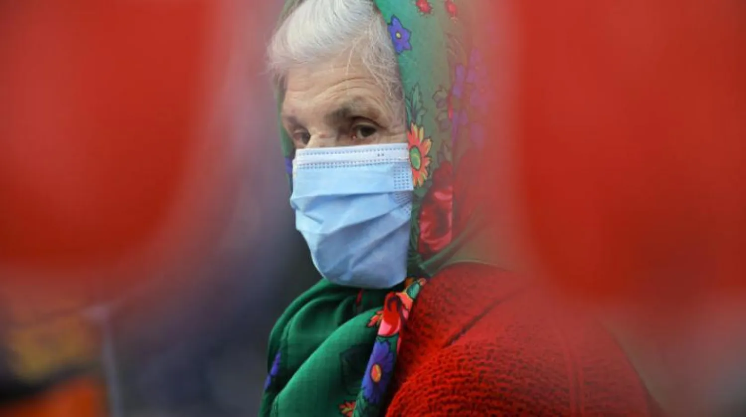 Romanya'da koruyucu maske takan yaşlı bir kadın  (AP) 

