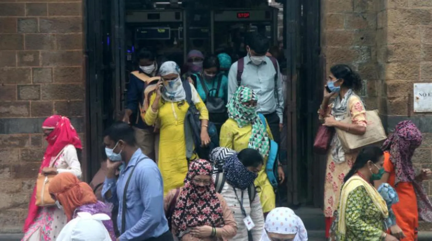 Mumbai’deki bir tren istasyonun maske takan insanlar (Reuters)