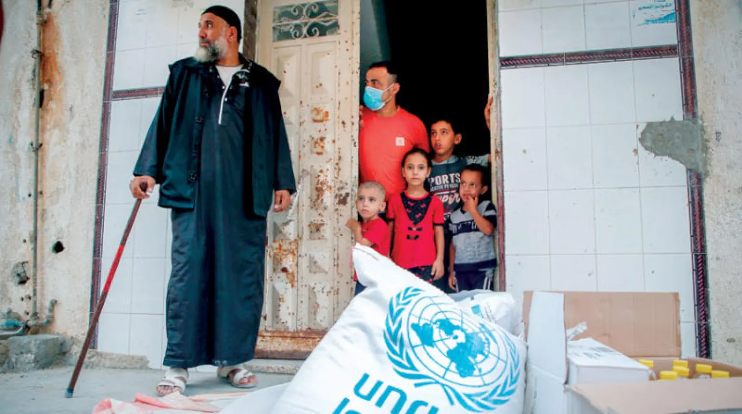 أسرة فلسطينية تتلقى مساعدات من الأنروا في غزة في 15 سبتمبر (أ.ف.ب)