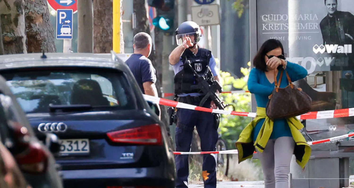 شرطي ألماني خلال فرض طوق حول مدرسة أُخليت بعد صدور إنذار لم يتضح سببه في إحدى ضواحي برلين أمس (أ.ف.ب)