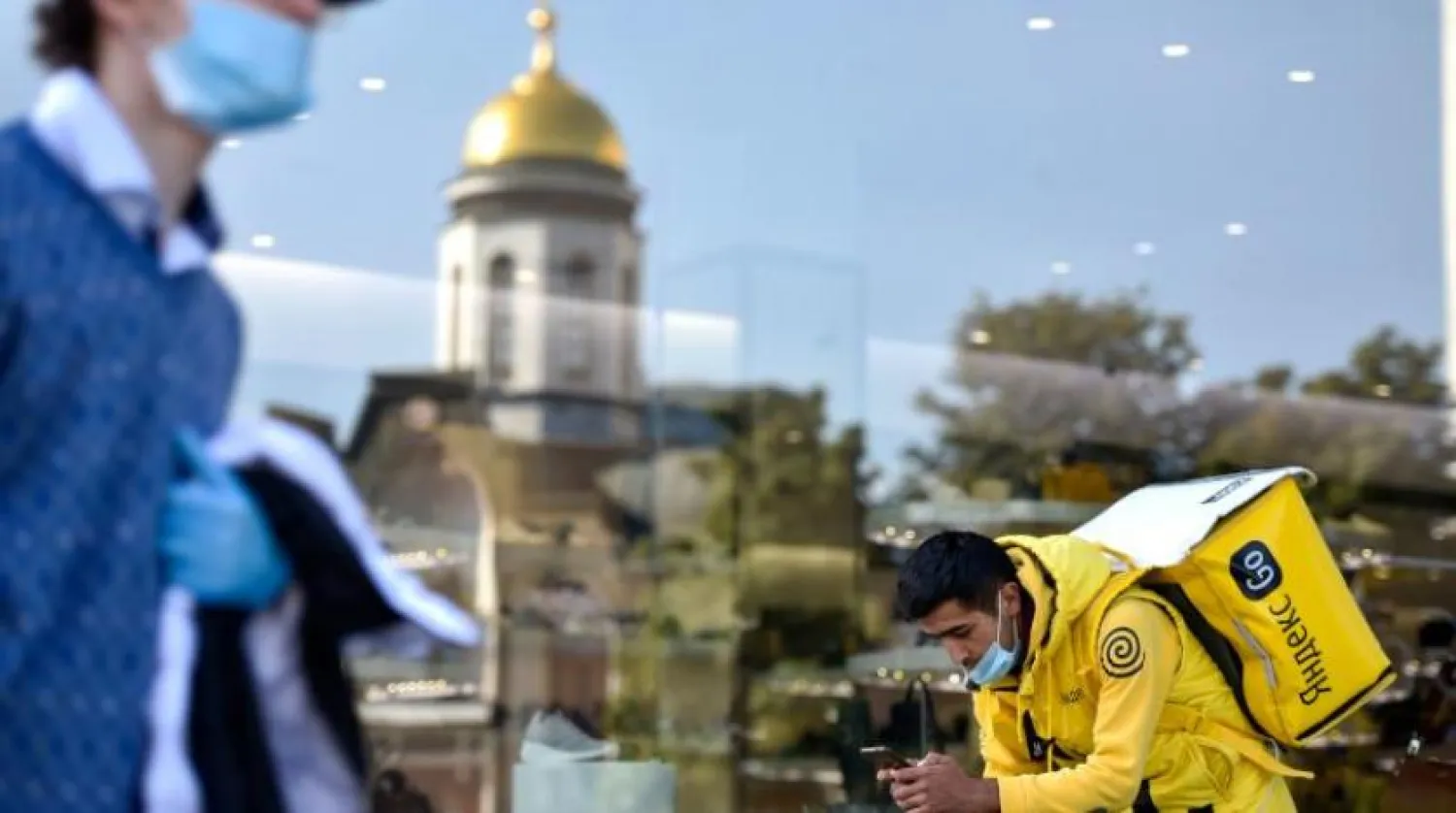 Moskova’da maske ile yemek servisi yapan bir çalışan (AFP)