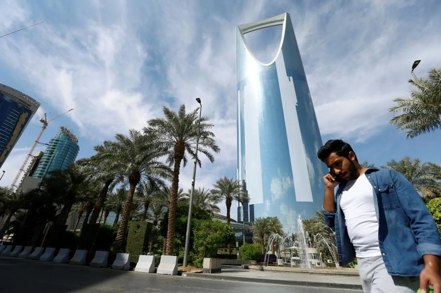 A man speaks on the phone as he walks past the Kingdom Centre Tower in Riyadh, Saudi Arabia, November 5, 2017. REUTERS/Faisal Al Nasser - /File Photo
