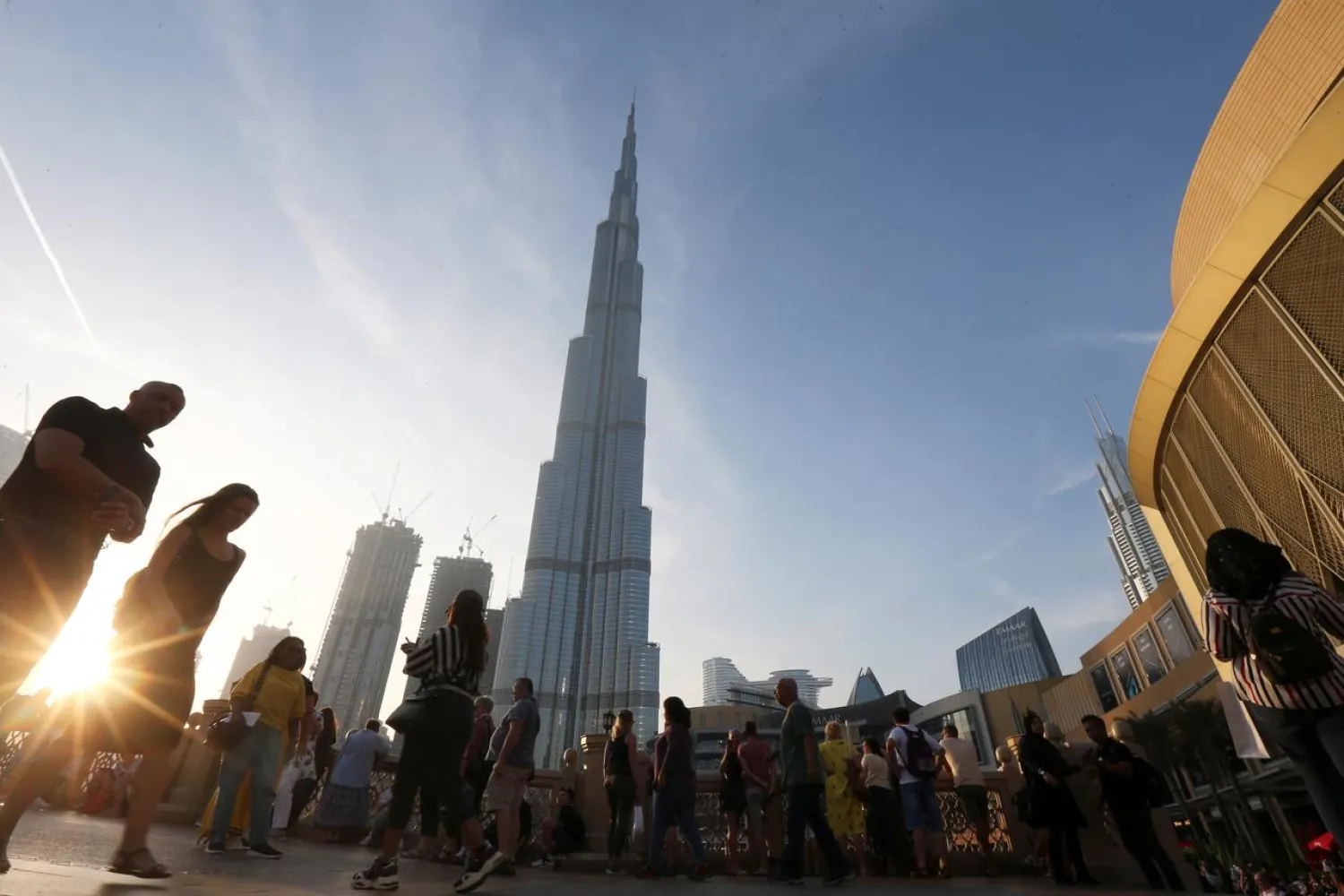 FILE PHOTO: People are seen in front of Burj Khalifa, the world's tallest building, in Dubai, United Arab Emirates March 12, 2020. REUTERS/Satish Kumar