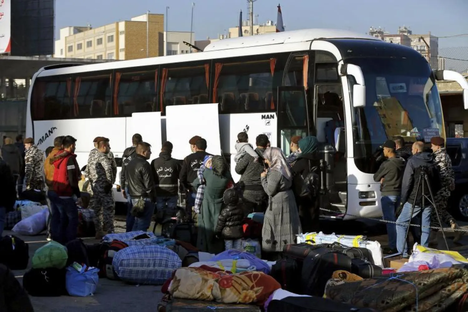 Members of the Lebanese General Security Directorate oversee Syrian refugees boarding a bus to take them home to Syria, in the northern Beirut suburb of Burj Hammoud, Lebanon, Thursday, Jan. 24, 2019.  © 2019 AP Photo/Bilal Hussein
