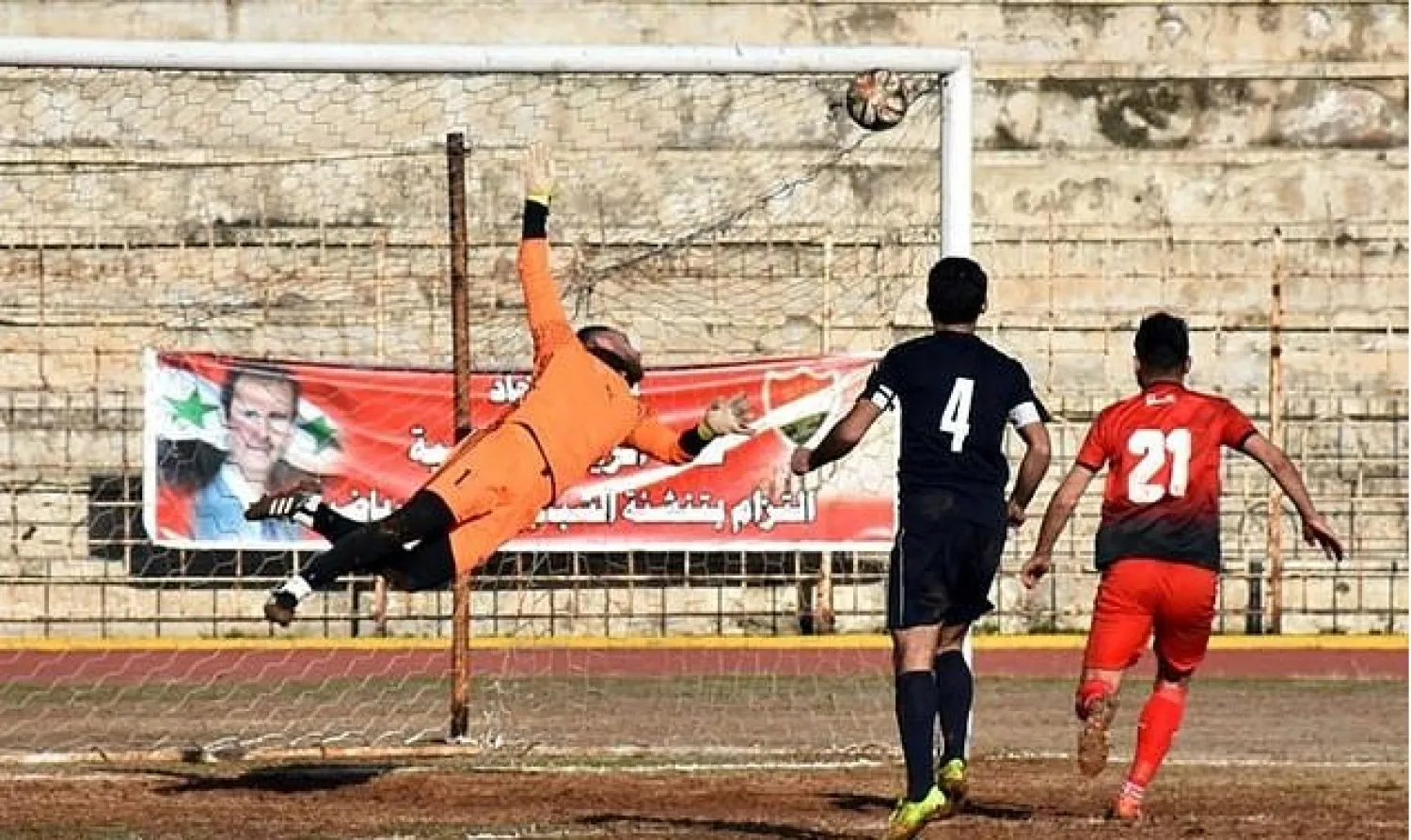 Al-Ittihad's goalkeeper dives to make a save during a Syrian league football match between derby rivals Al-Ittihad (in red) and Al-Hurriya, in the northern city of Aleppo in January 2017. AFP
