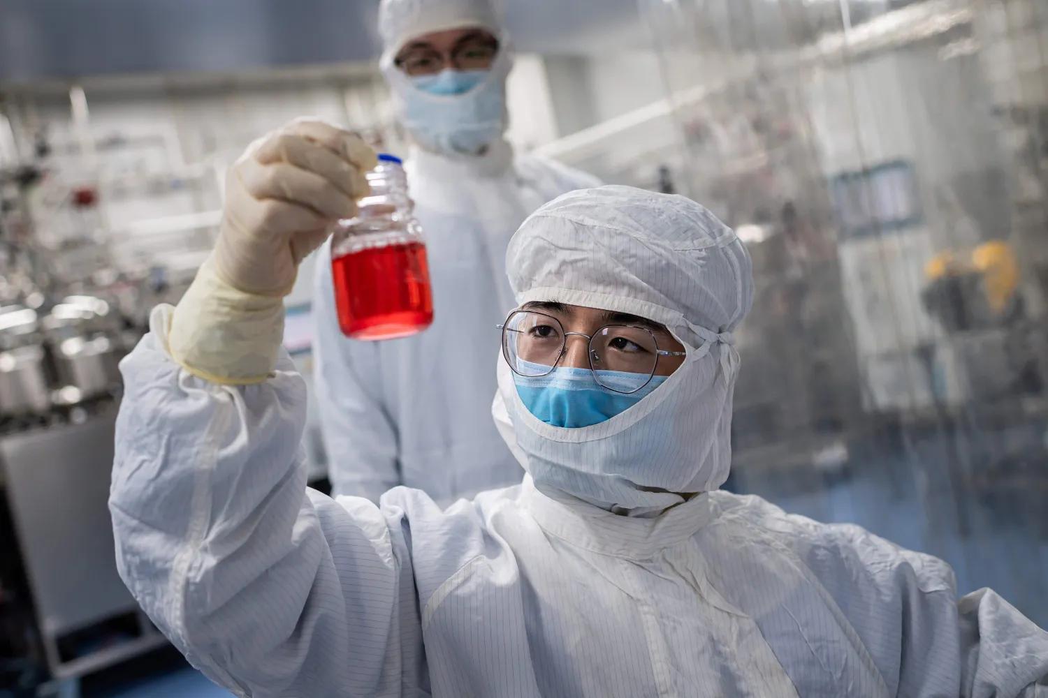 In this April 29, 2020, file photo an engineer looks at monkey kidney cells as he makes a test on an experimental vaccine for the COVID-19 coronavirus inside the Cells Culture Room laboratory at the Sinovac Biotech facilities in Beijing. (Photo by NICOLAS ASFOURI / AFP)