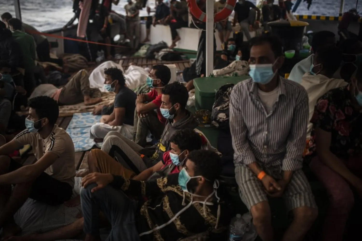 Migrants from different nationalities rest on board the Spanish NGO Open Arms Vessel on September, 9, 2020 after being rescued the night before as they were trying to flee Libya on board a precarious wooden boat in international waters, in the Central Meditarranean sea. (AP Photo/ Santi Palacios) 