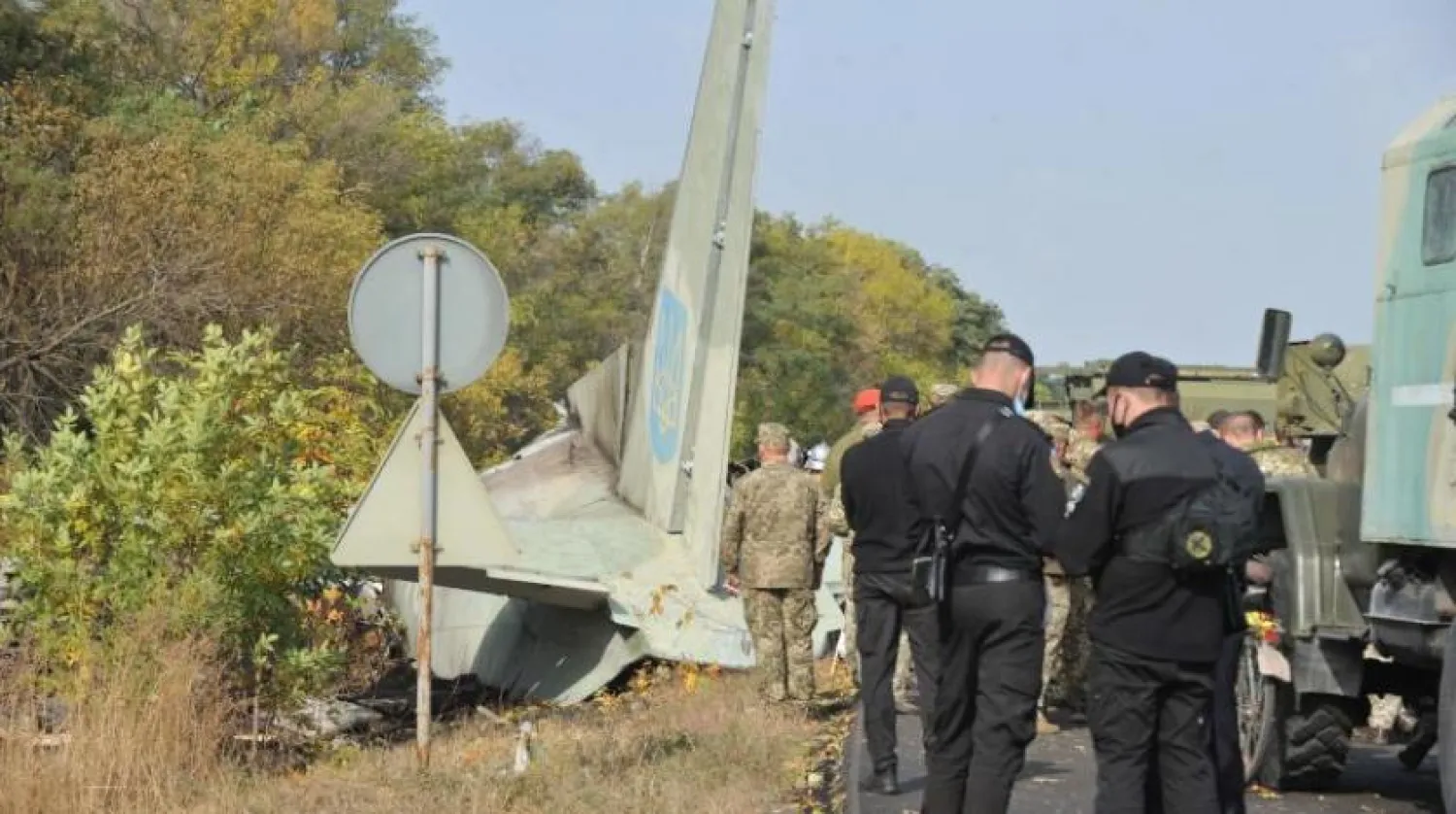 Dün düşen Ukrayna uçağının enkazının yanında asker ve uzmanlar (AFP)
