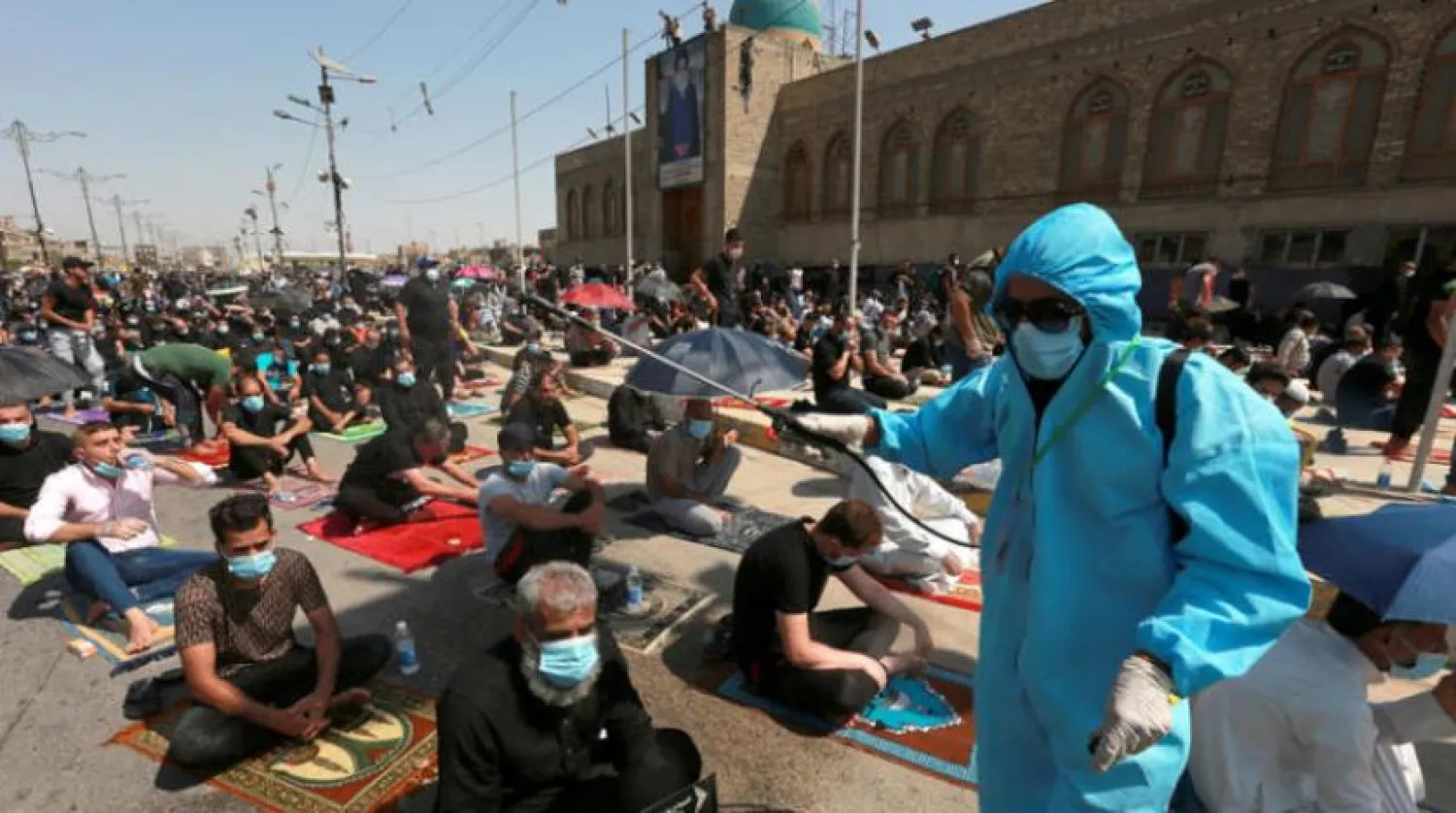 Bir sağlık çalışanı, önceki gün Sadr Şehri’deki bir camide namaz kılanların üzerine steril çözelti püskürtüyor (EPA)