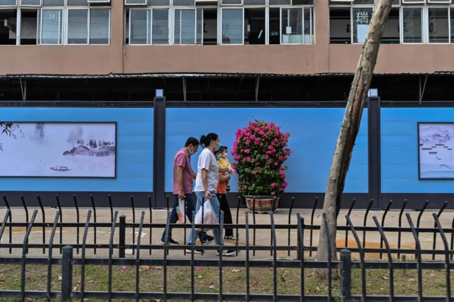 أشخاص يضعون كمامات في أحد شوارع ووهان (أ.ف.ب)