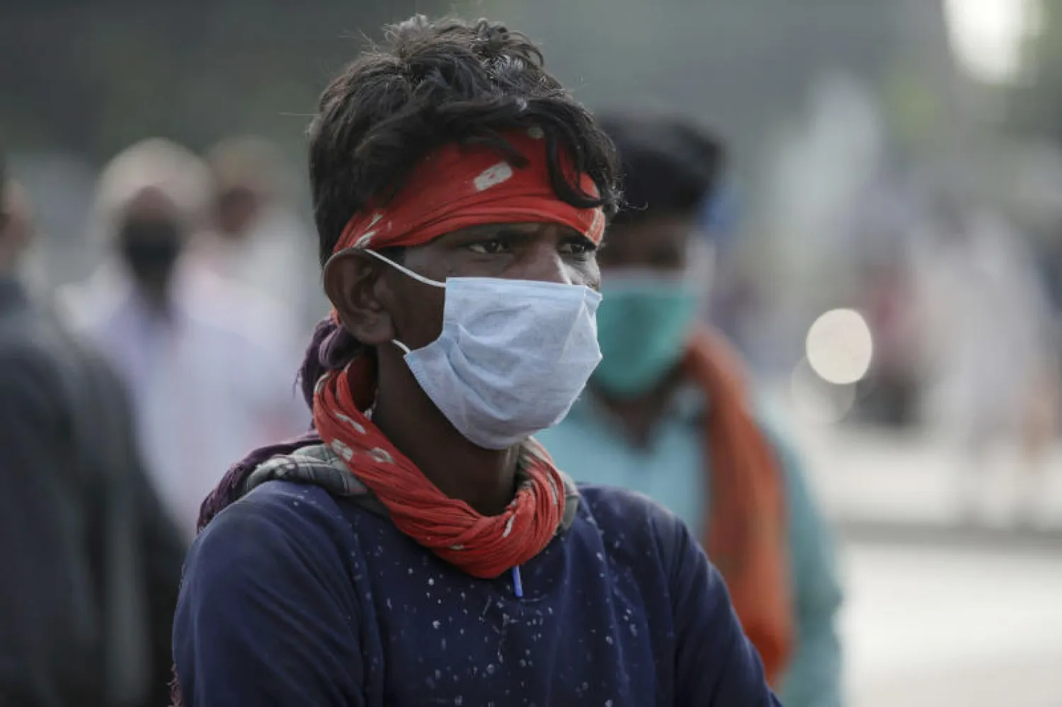 هندي يرتدي قناعاً واقياً في أحد شوارع البلاد (أ.ب)