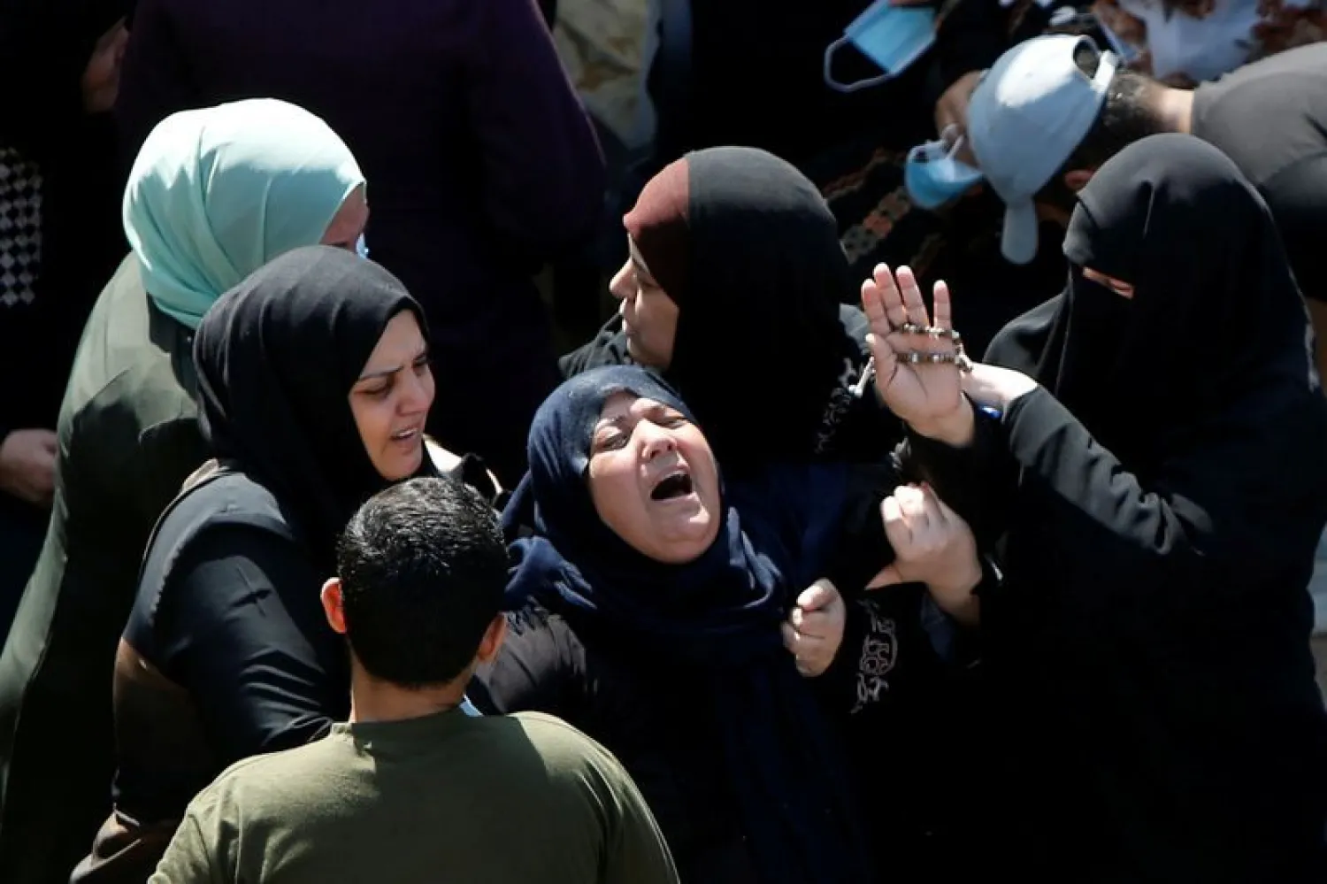 Mourners comfort the mother of two Palestinian fishermen | AFP