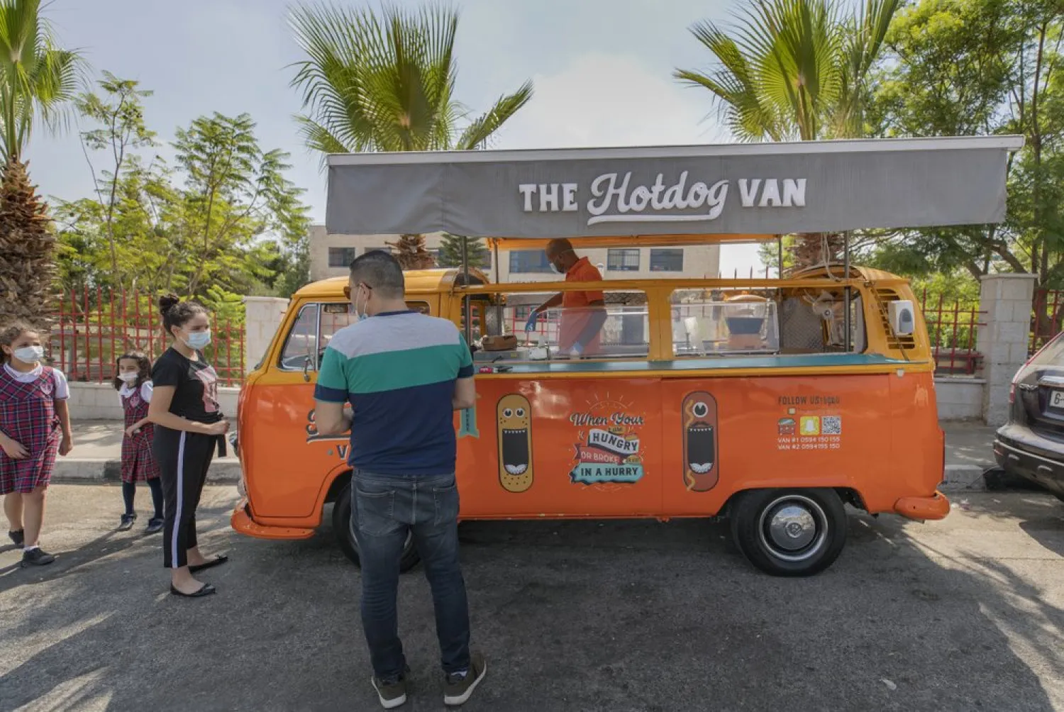 Emad Abdeljawwad sells grilled hot dogs and beverages out of a converted van in the West Bank city of Ramallah, Wednesday, Sept. 23, 2020. (AP)