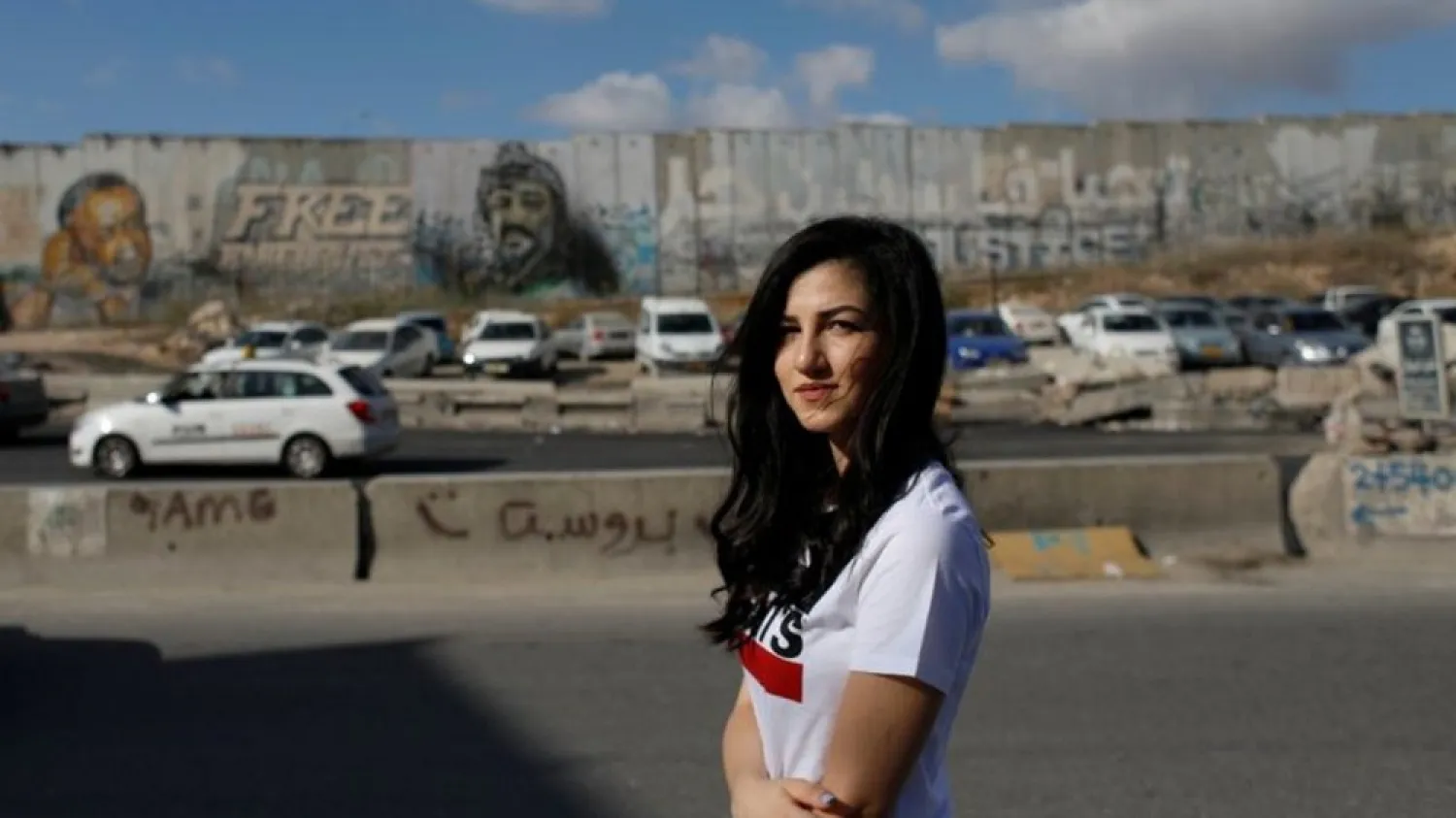 Palestinian Leen Anabtawi, 24, poses for a photo in front of the Israeli barrier near Ramallah in the Israeli-occupied West Bank September 24, 2020. (Reuters)