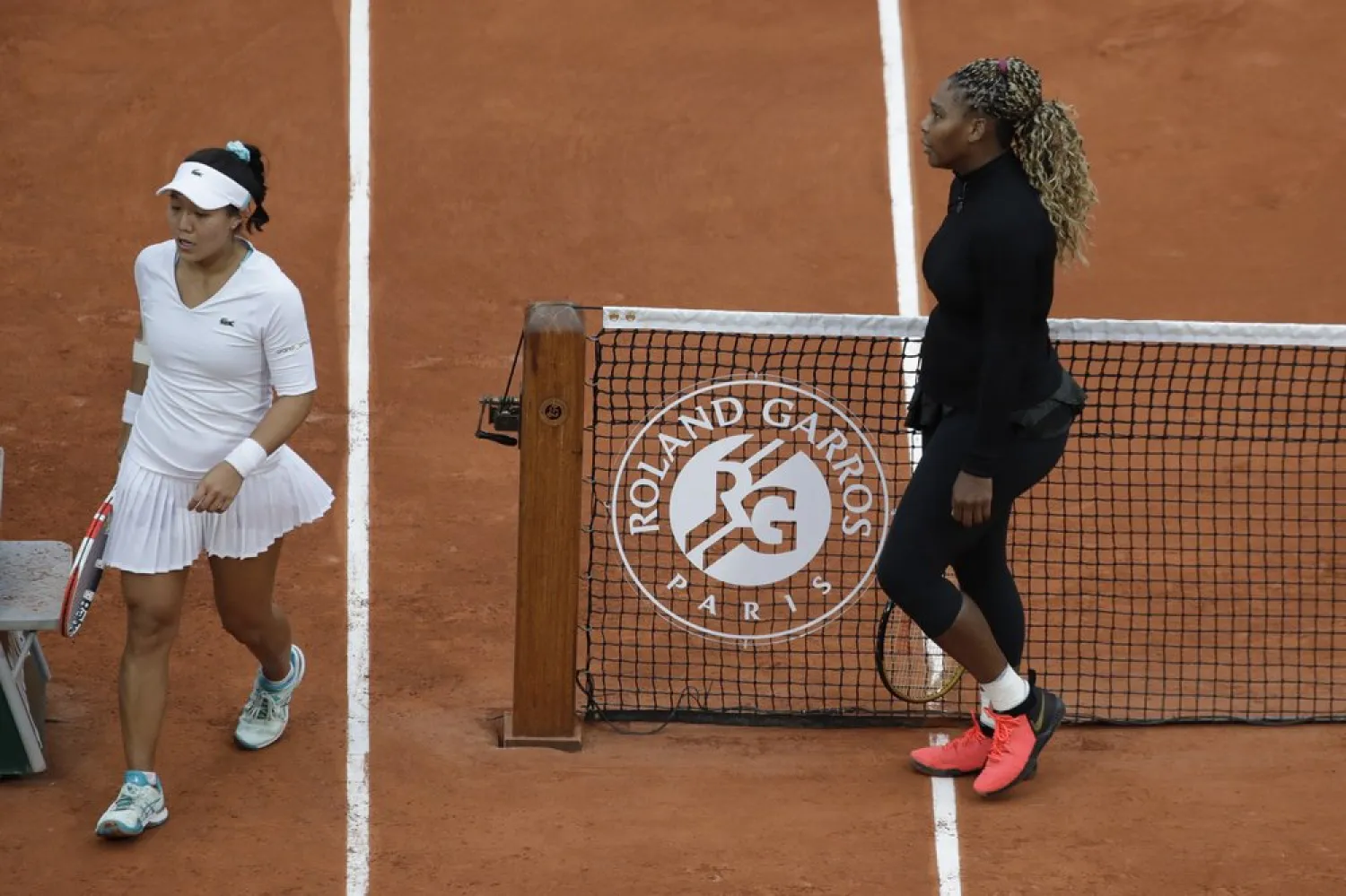 Serena Williams walks to her bench after defeating Kristie Ahn, left, in the first round match of the French Open tournament in Paris, France, Sept. 28, 2020. (AP)