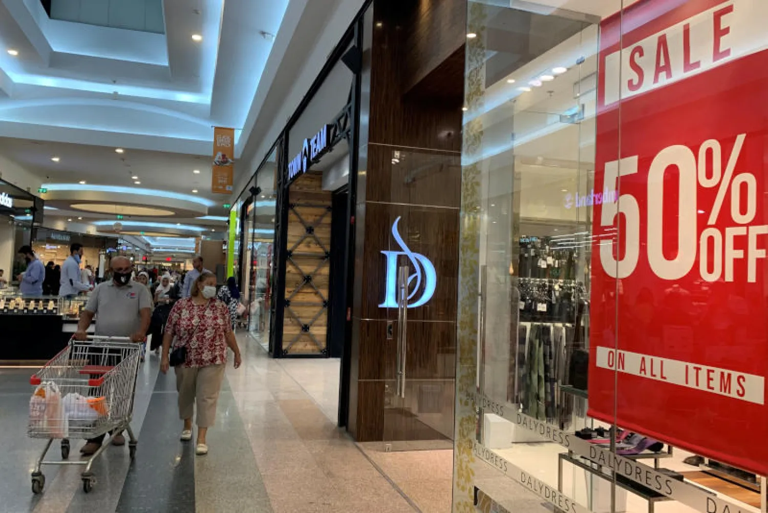 متسوقون يضعون أقنعة واقية يسيرون داخل أحد المحلات التجارية الكبرى في القاهرة (رويترز)