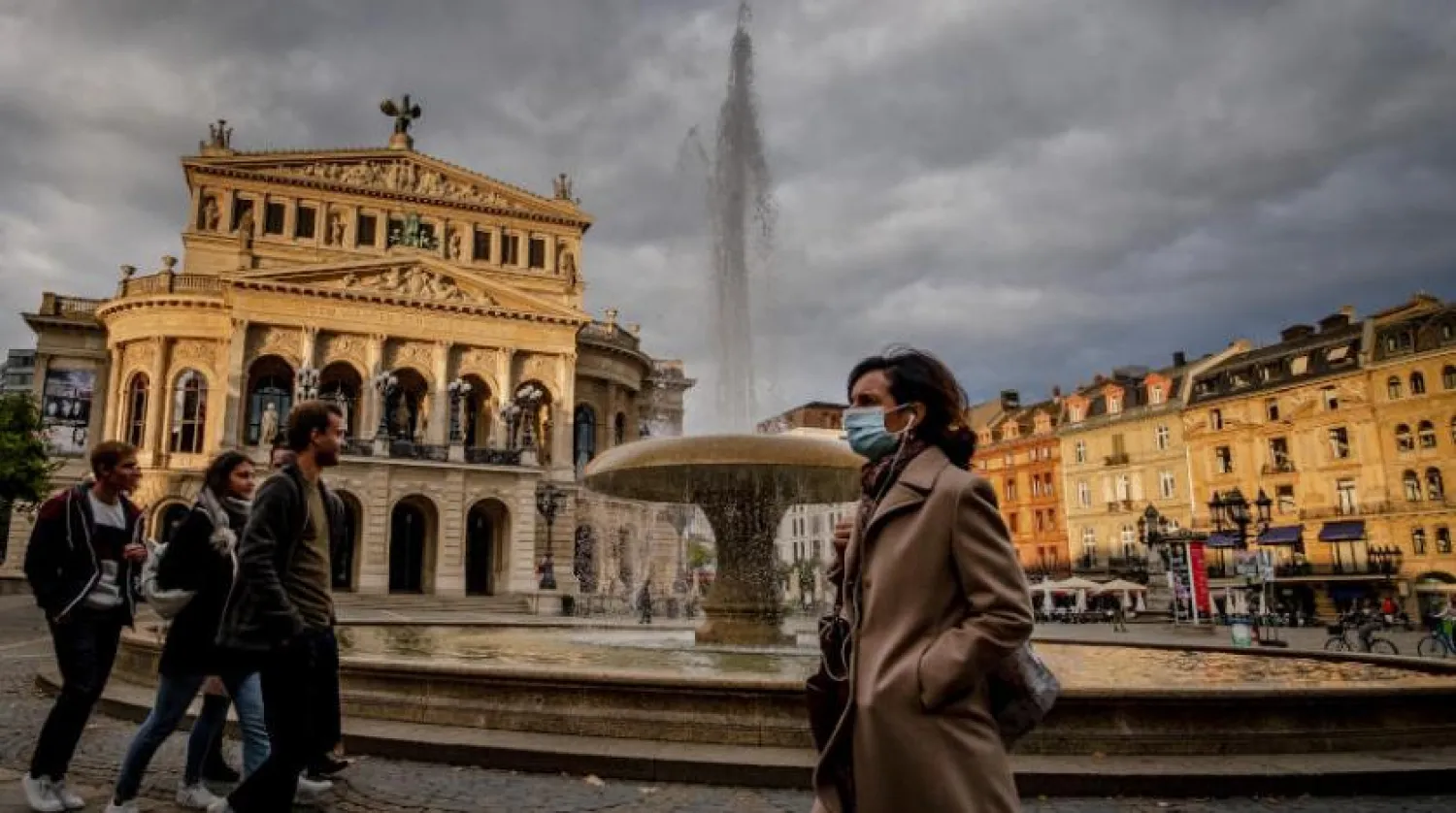 Bir kadın eski Frankfurt opera binası önünde koruyucu maske takıyor (AP)