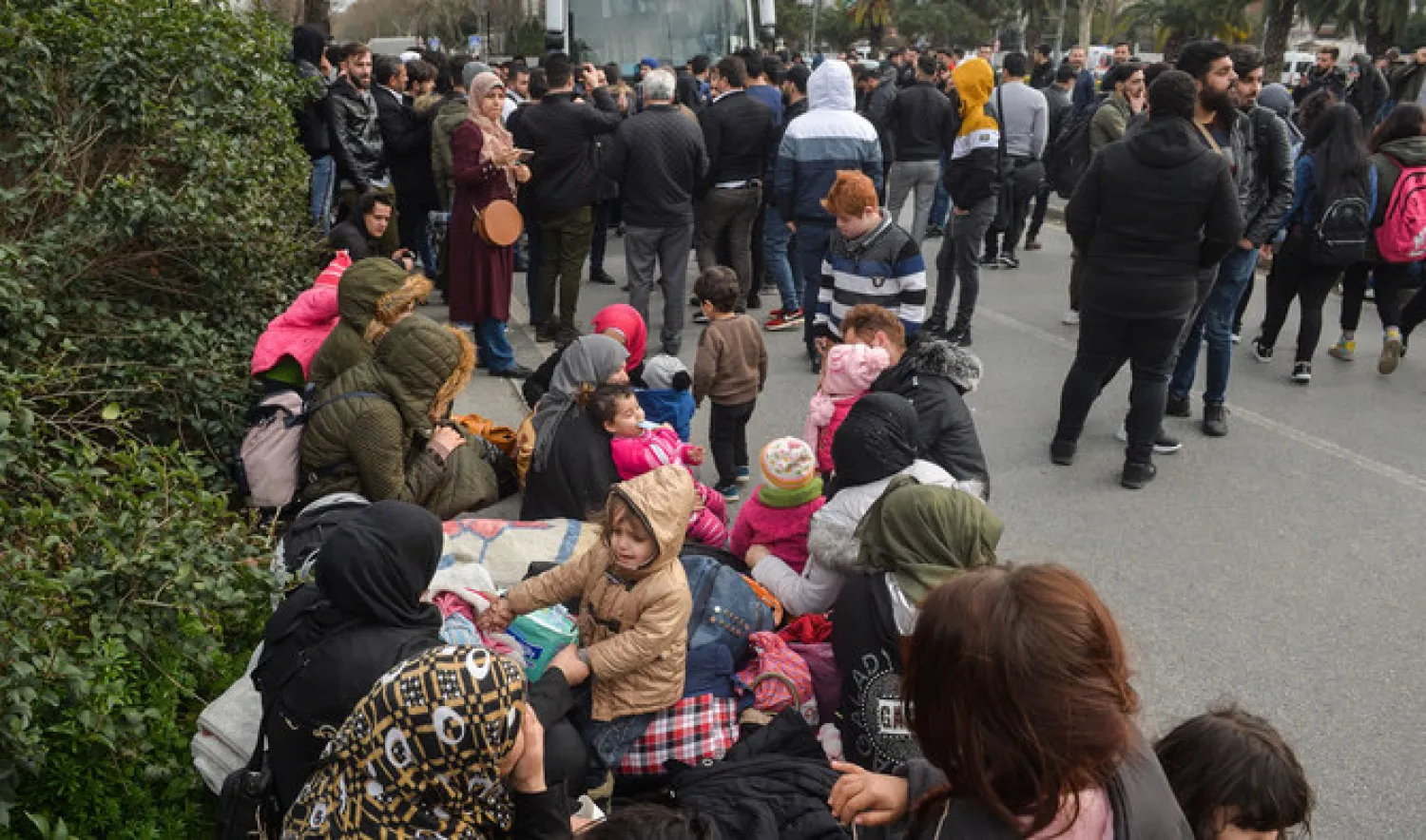 Migrants stand in front of a bus before boarding to go to the Greek border, in Istanbul, Turkey. (AFP)
