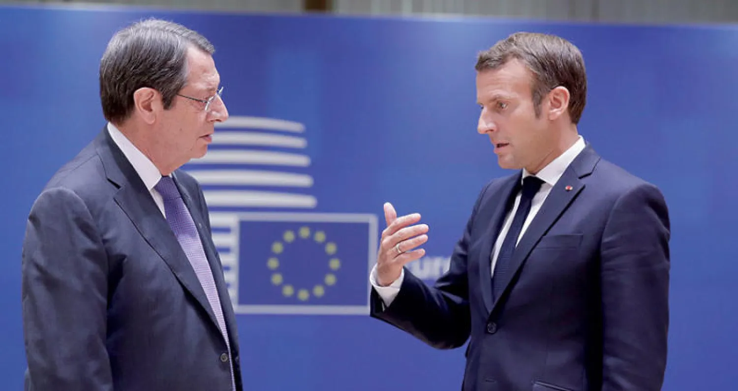 الرئيس الفرنسي إيمانويل ماكرون والرئيس القبرصي نيكوس أنستاسيادس في القمة الأوروبية في بروكسل أمس (رويترز)