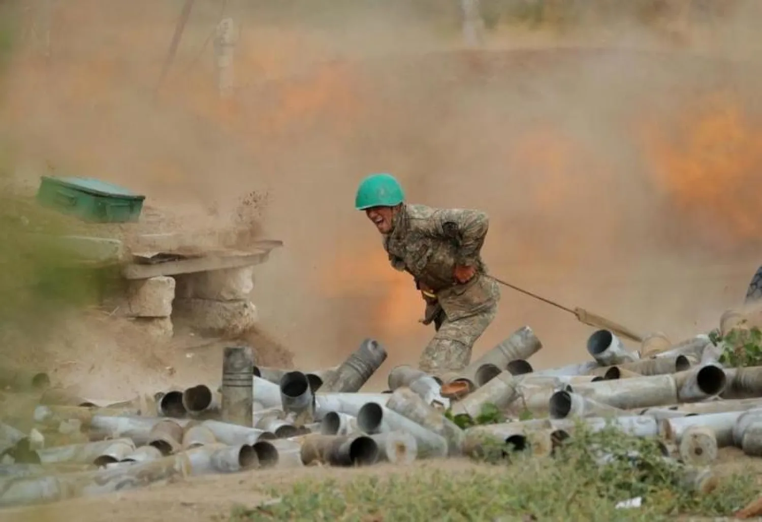 جندي من الجيش الأرميني يطلق قذيفة مدفعية أثناء القتال مع القوات الأذربيجانية (رويترز)