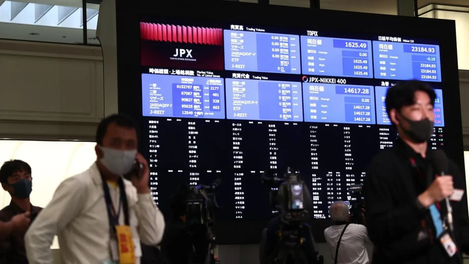 Journalists gather next to an information board inside the Tokyo Stock Exchange where trading was halted due to a glitch on the market on October 1. AFP