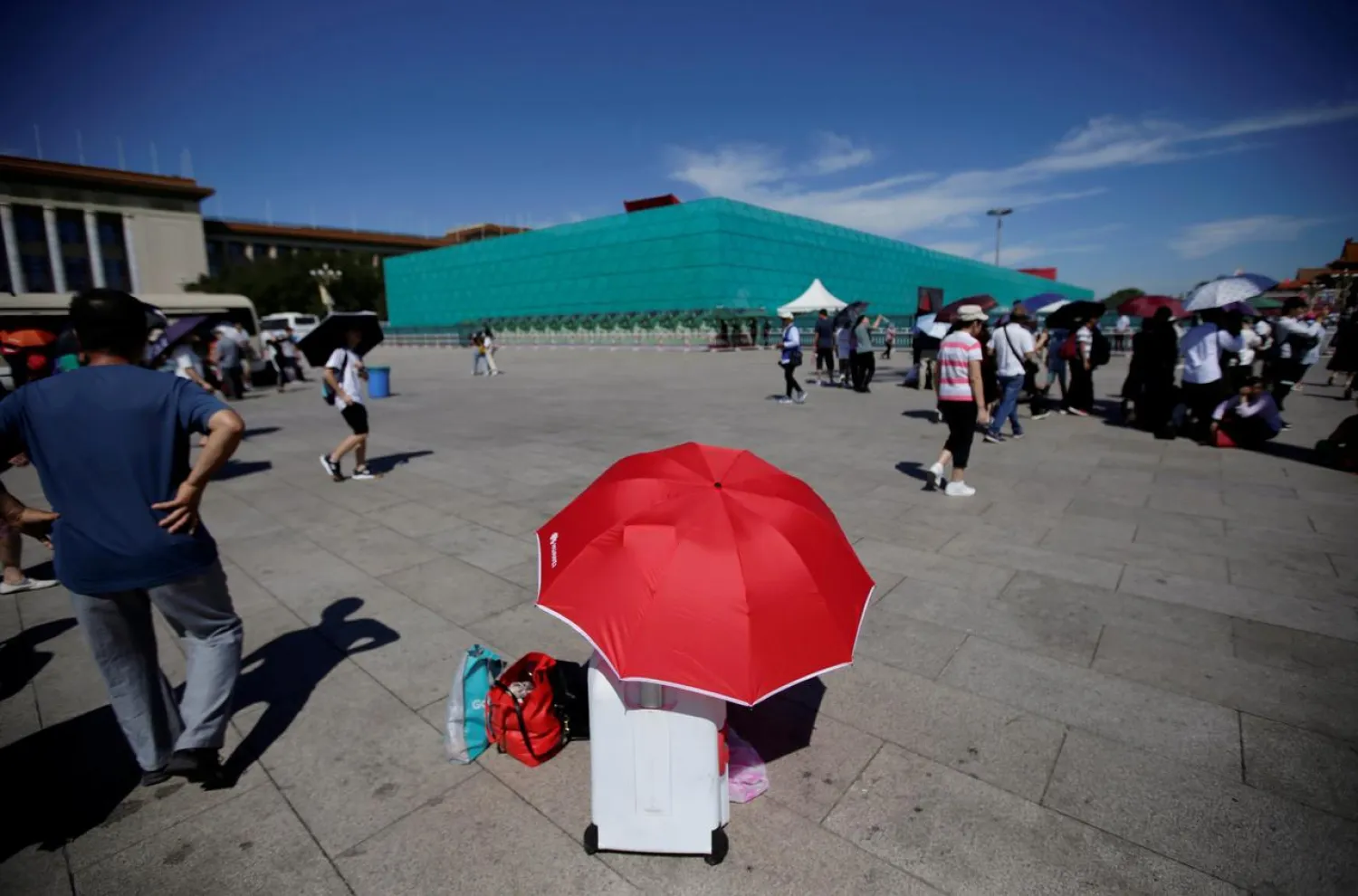FILE PHOTO: A tourist rests under an umbrella next to the installations set up on Tiananmen Square for the 70th anniversary of the founding of People's Republic of China on October 1, in Beijing, China August 27, 2019. REUTERS/Jason Lee/File Photo