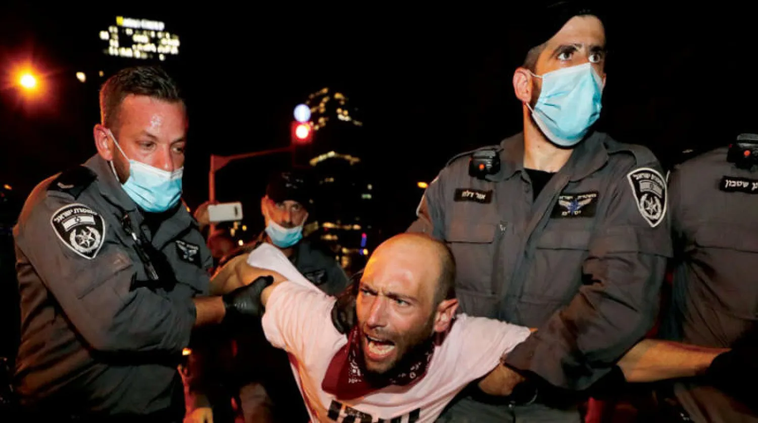 اعتقال أحد المحتجين ضد قرار منع المظاهرات في تل أبيب (رويترز)