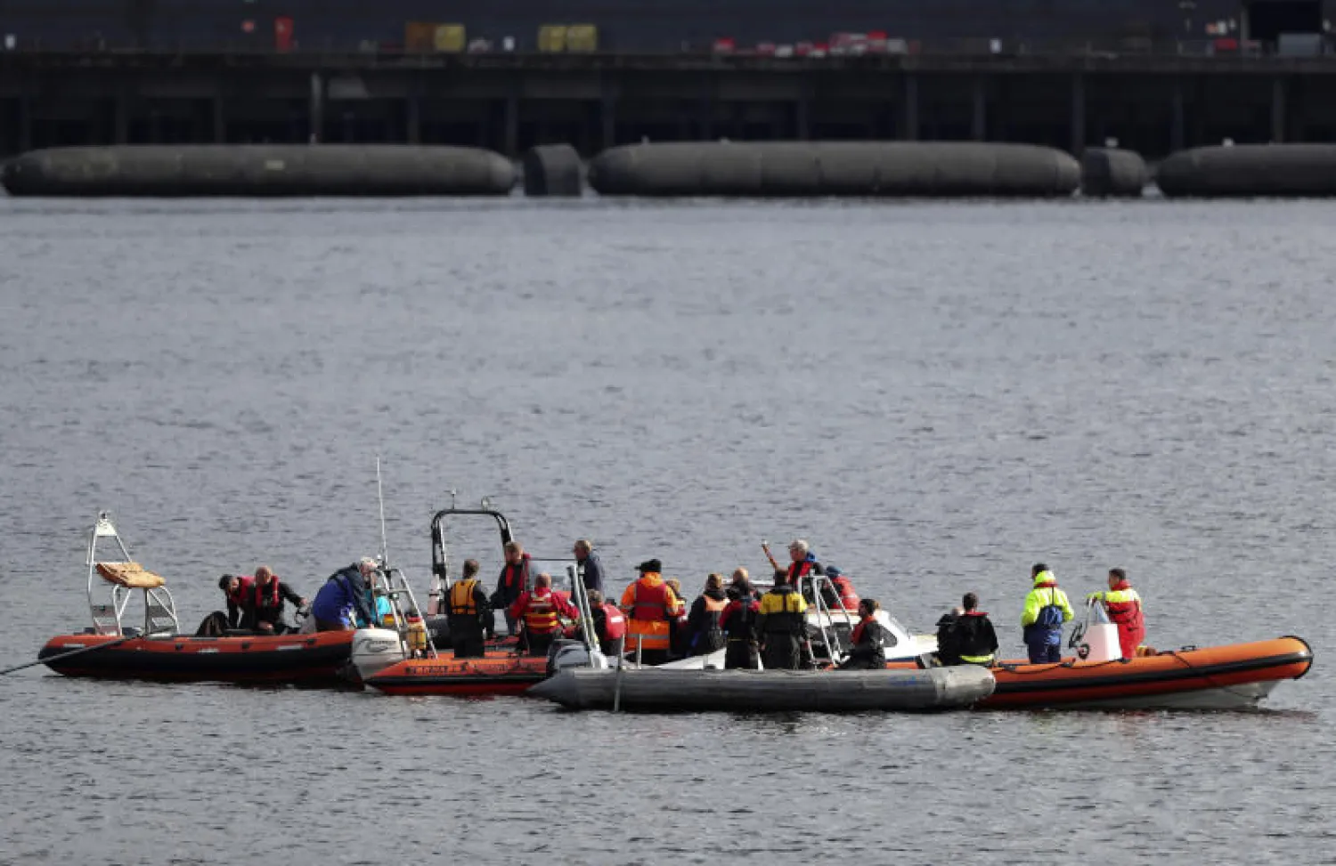 فرق تستقل قوارب ضمن عمليات البحث عن الحيتان في بحيرة تقع قرب غلاسغو بغرب اسكوتلندا (رويترز)