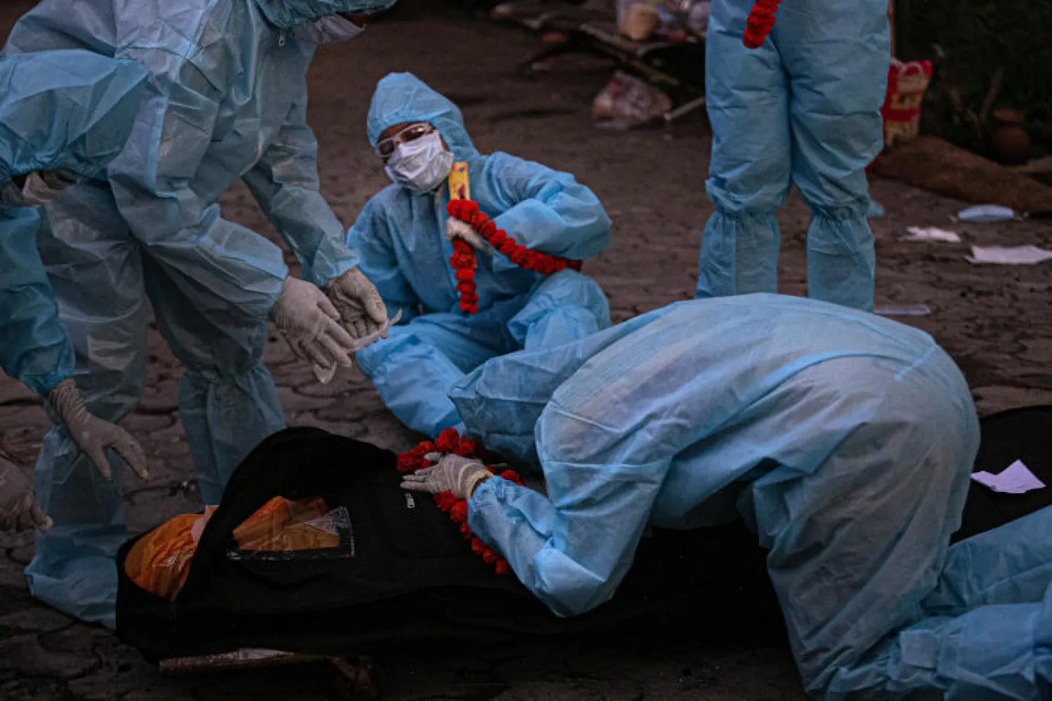 مواطنون يرتدون الملابس الواقية أثناء توديعهم احد ضحايا فيروس كورونا في الهند (أ.ب)