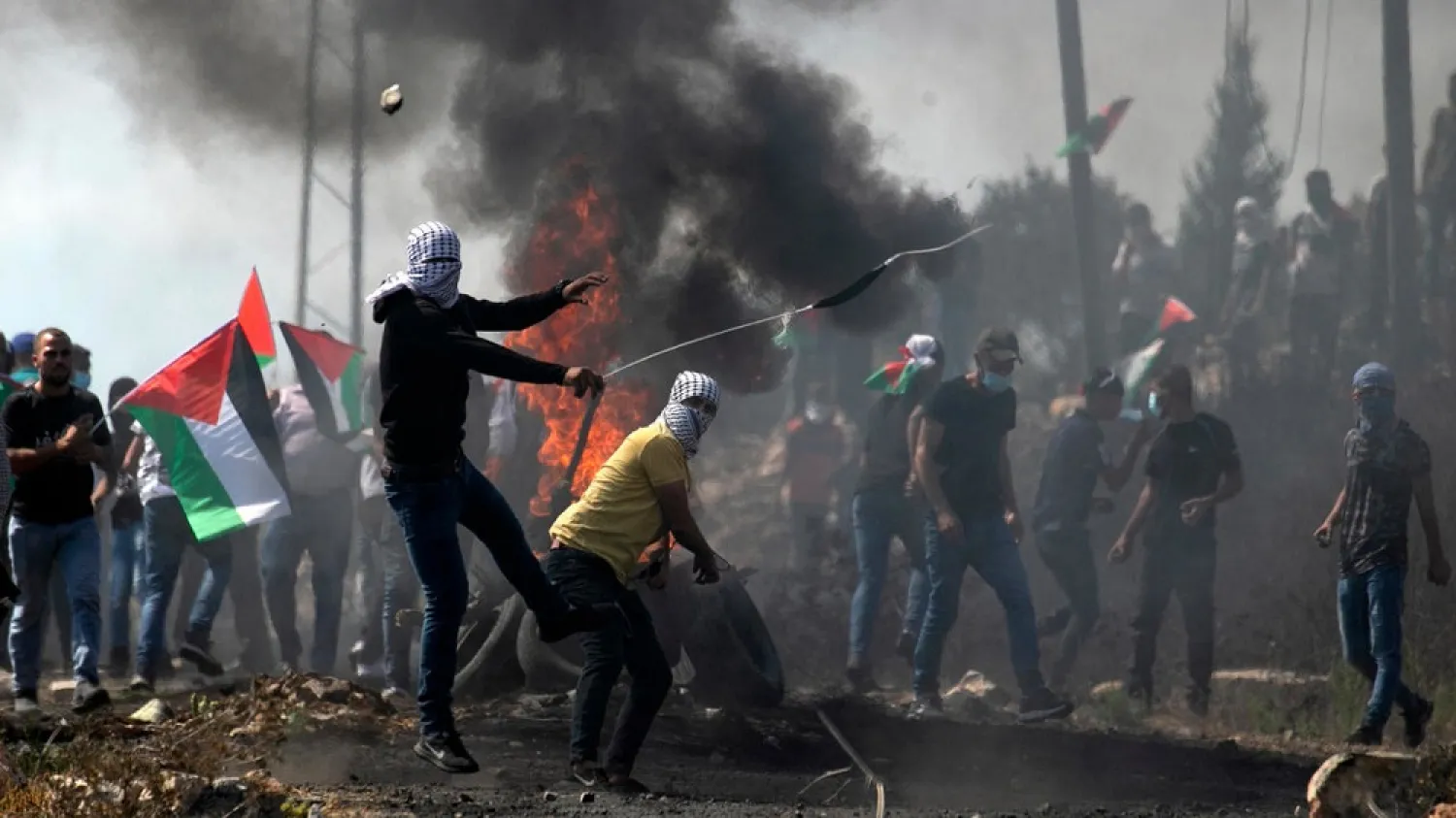 Palestinian protesters hurl stones at Israeli troops during a demonstration in the occupied West Bank village of Kfar Qaddum. (AFP)