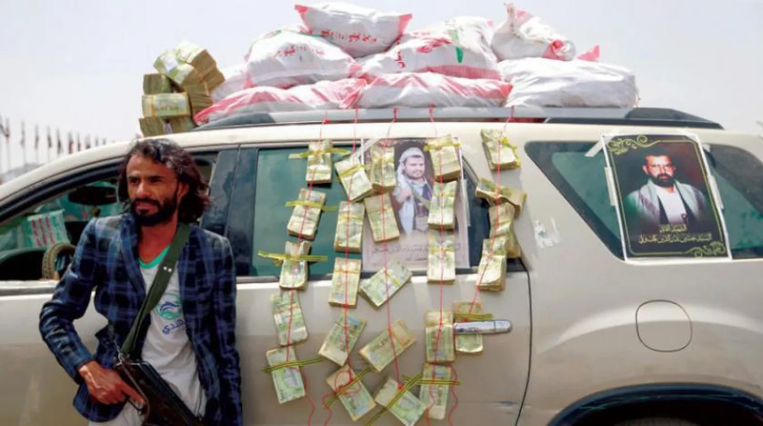 A Houthi gunman guards a car decorated with money  (AFP)

