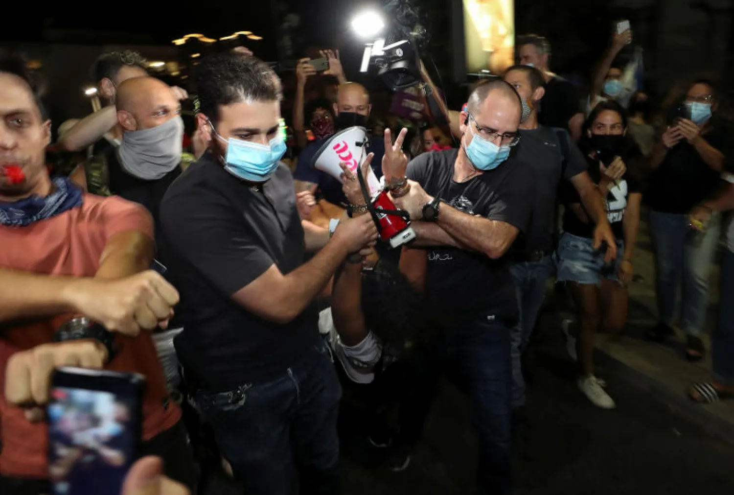 ضباط شرطة يعتقلون أحد المتظاهرين في تل أبيب (رويترز)