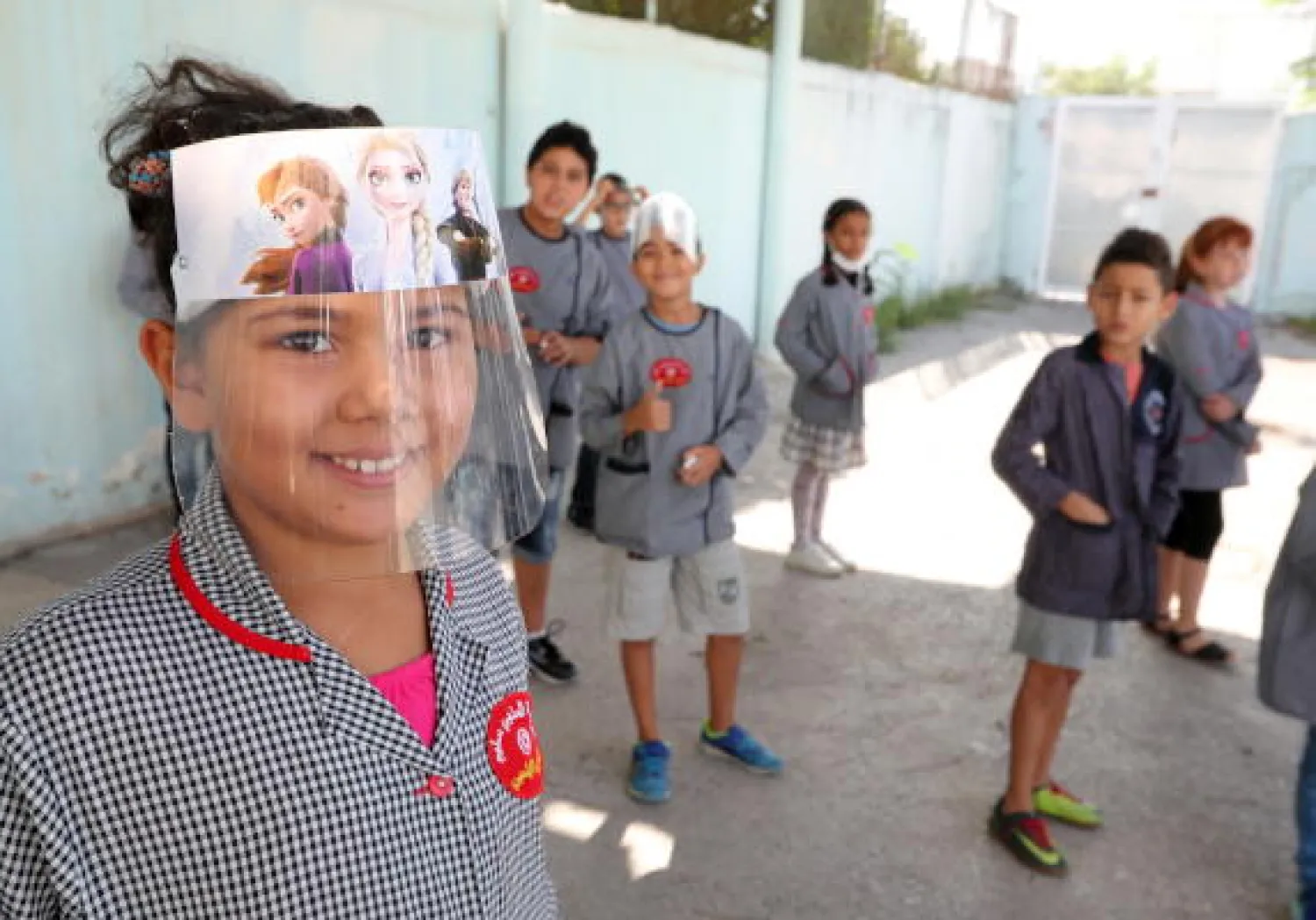 طفلة تونسية ترتدي واقي الوجه في أحد المدارس بالعاصمة تونس (إ.ب.أ)