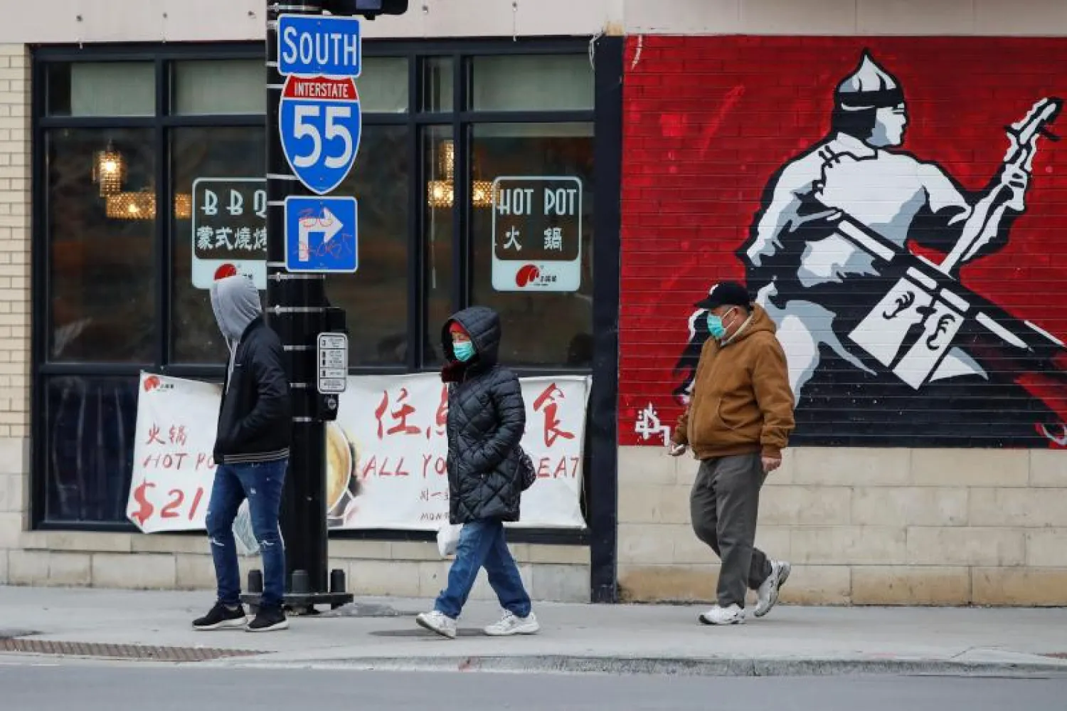 أشخاص يرتدون الكمامات في الحي الصيني بشيكاغو (رويترز)