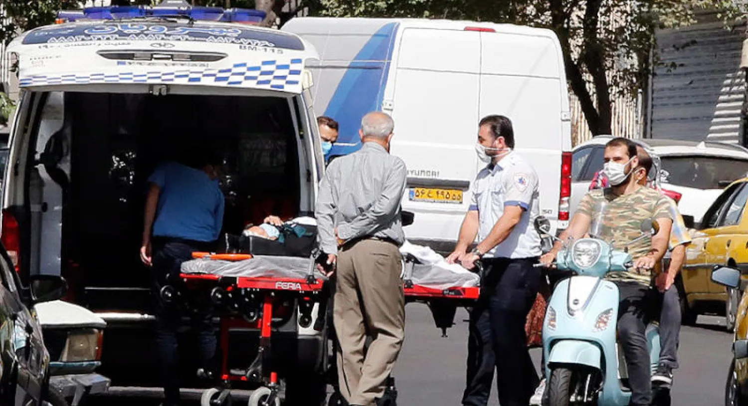 عاملون في الطوارئ الإيرانية ينقلون مريضاً إلى المستشفى وسط تصاعد الإصابات بفيروس كورونا في طهران أمس (إ.ب.أ)